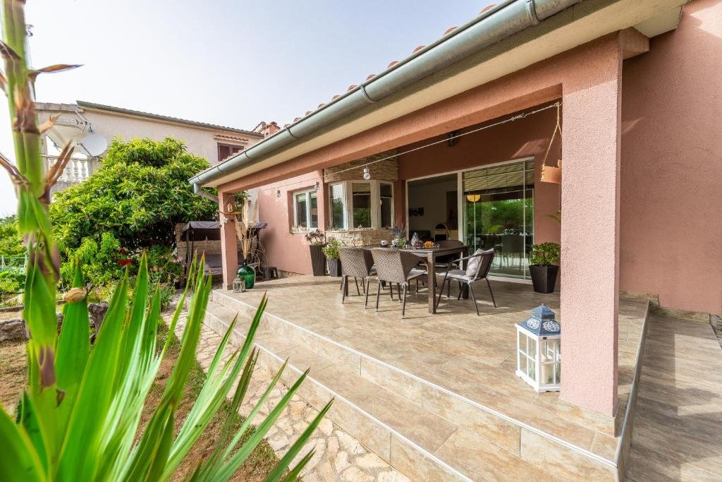 Terracotta house with a tiled terrace and green garden