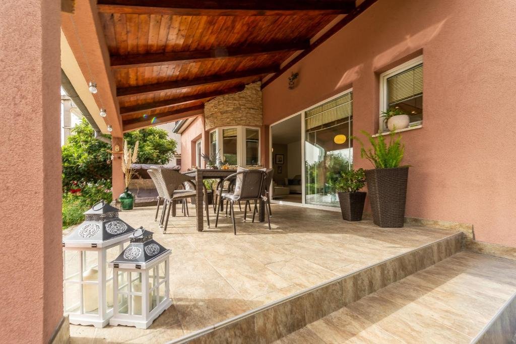 Covered terrace with wooden beams, rattan chairs and lanterns